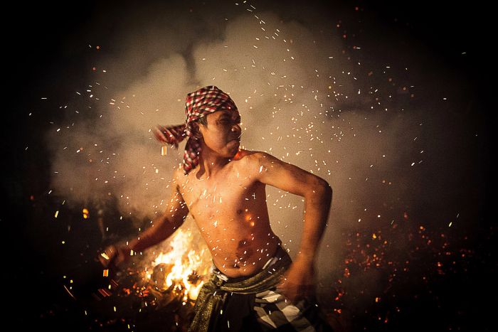 A Balinese man throws a burned coconut husk during the Mesabatan Api ritual ahead of Nyepi Day on March 30, in Gianyar, Bali, Indonesia.