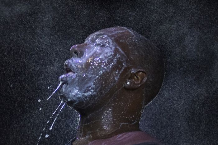 A man is doused with milk and sprayed with mist after being hit by an eye irritant from security forces trying to disperse demonstrators in Ferguson, Missouri, on Aug. 20.