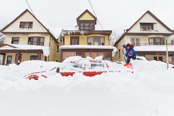 Lori Weishaar shovels snow from around her vehicle following an autumn snow storm in Buffalo, New York, Nov. 20.
