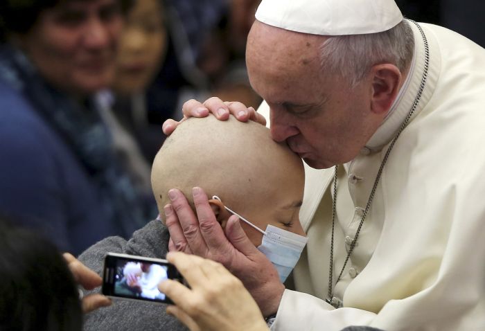 Pope Francis right kisses a girl during a special audience with business consultants at the Paul VI hall at the Vatican, Nov. 14.