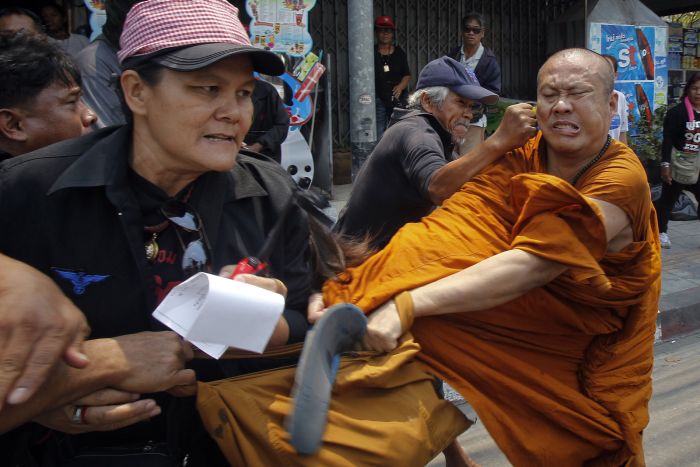 Members of the pro-government red shirt movement attack a Buddhist monk outside the National Anti-Corruption Commission office in Nonthaburi province, on the outskirts of Bangkok, March 24.