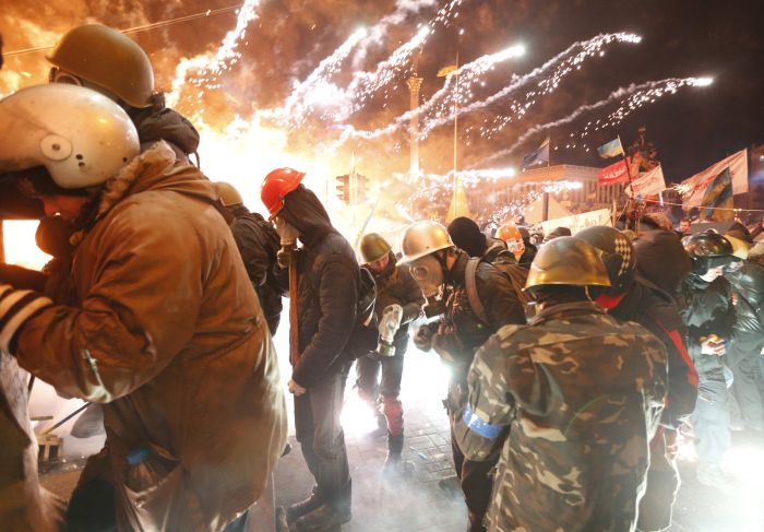 Fireworks explode near anti-government protesters during clashes with riot police at the Independence Square in Kiev, Feb. 18.