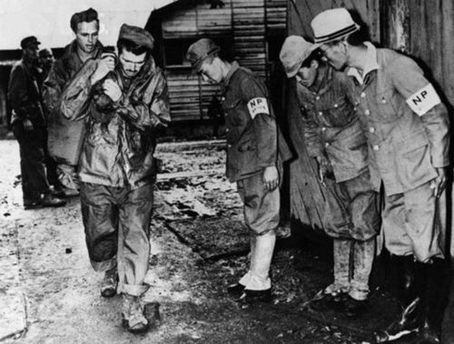 Japanese guards bow before US prisoners of war being released from a Yokohama detention center following the capitulation of Japan, 1945
