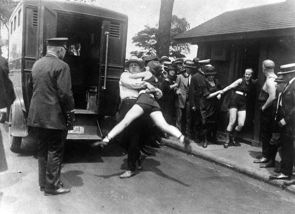 Woman being arrested for wearing one piece bathing suit  showing a little leg. 1922 Chicago