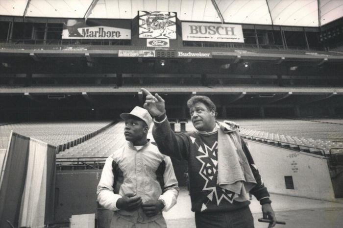 1989, the Detroit Lions drafted Barry Sanders. Here he is being toured through the Pontiac Silverdome by coach Wayne Fontes