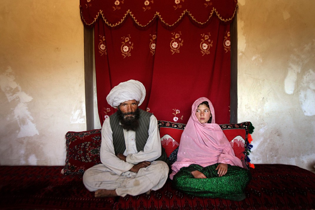 Faiz, 40, and Ghulam, 11, sit for a portrait in her home before their wedding in Afghanistan. According to the U.S. Department of State report “Human Rights Practices for 2011,” approximately 60 percent of girls were married younger than the legal age of 16. Once the girl’s father has agreed to the engagement, she is pulled out of school immediately.