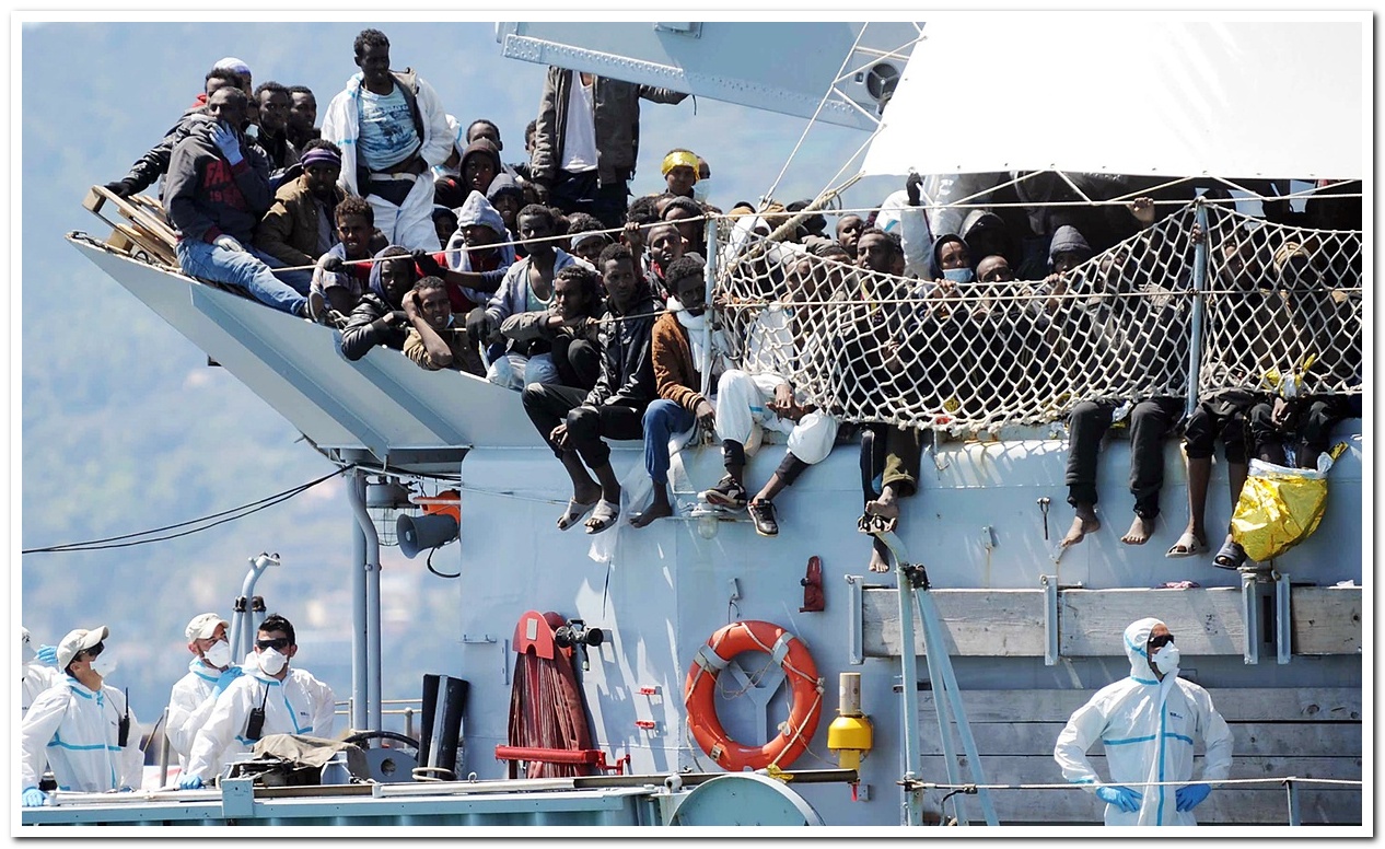Refugees wait to disembark from the Italian Navy vessel Chimera in the harbor of Salerno, Italy.