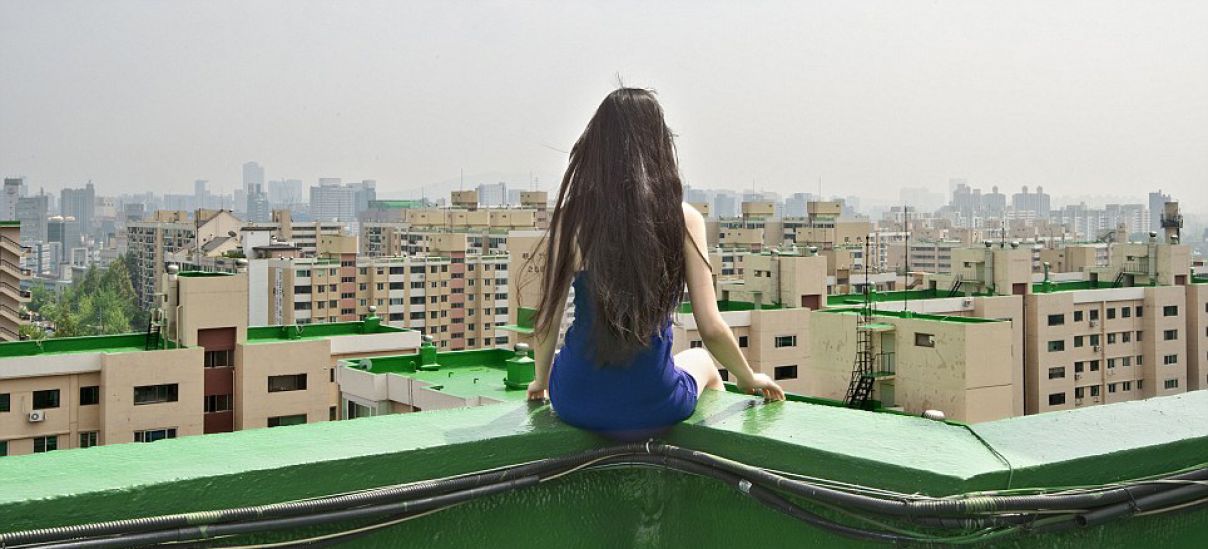 Ahn dangles over the edge of a rooftop in Seoul, South Korea.