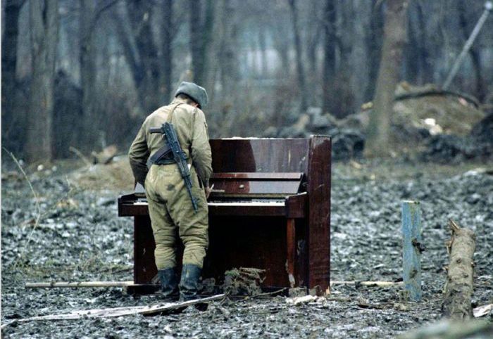 A Russian soldier playing an abandoned piano in Chechnya in 1994