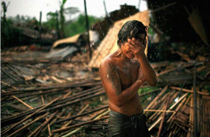 Hhaing The Yu, 29, holds his face in his hand as rain falls on the decimated remains of his home near Myanmars capital of Yangon Rangoon. In May 2008, cyclone Nargis struck southern Myanmar, leaving millions homeless and claiming more than 100,000 lives