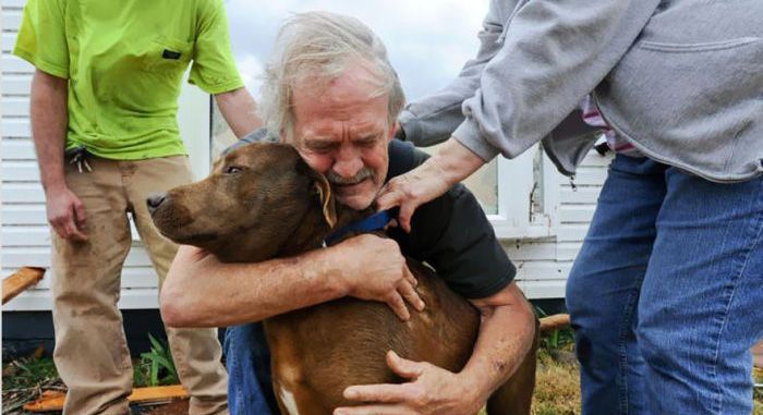 Greg Cook hugs his dog Coco after finding her inside his destroyed home in Alabama following the Tornado in March, 2012