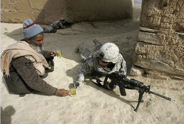 An Afghan man offers tea to soldiers