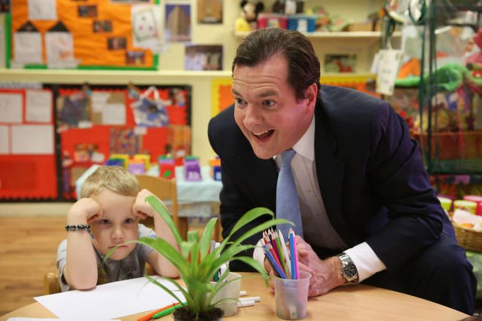 Chancellor of the Exchequer George Osborne plays with Titas during a visit to a nursery in Hammersmith, London.