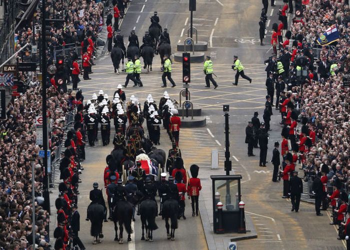 Police run across the path of the funeral cortege carrying the body of former Prime Minister Margaret Thatcher at Ludgate Circus in London, England.