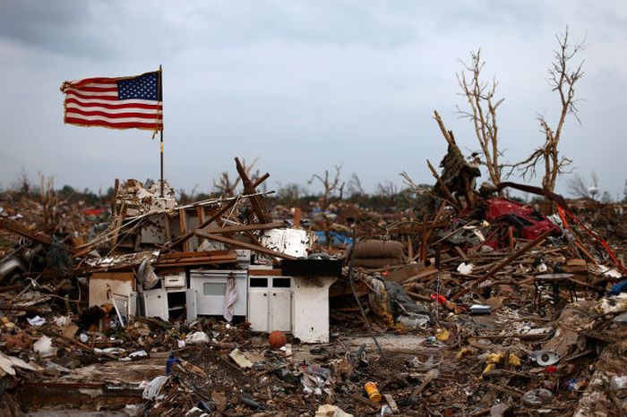 An American flag flies over the rubble of a destroyed neighbourhood on May 24, 2013 in Moore, Oklahoma. The tornado of EF5 strength and two miles wide touched down killing at least 24 people and leaving behind extensive damage to homes and businesses. U.S. President Barack Obama promised federal aid to supplement state and local recovery efforts.