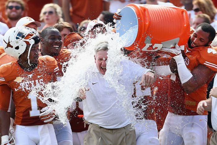 Head coach Mack Brown of the Texas Longhorns has a cooler of ice water dumped on him by his team after the Longhorns beat the Oklahoma Sooners 36-20 at the Cotton Bowl in Dallas, Texas.