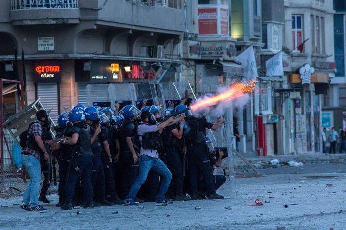 Riot police fire tear gas to disperse the crowd during a demonstration near Taksim Square in Istanbul, Turkey. Istanbul has seen protests rage on for days, with two protesters and one police officer killed.