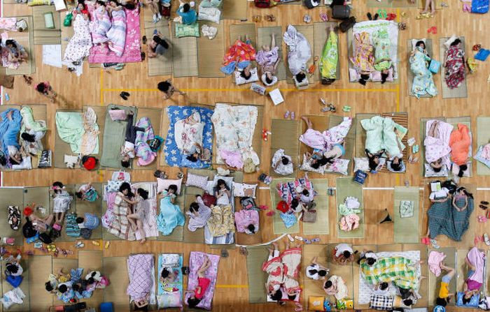 Students prepare to sleep on mats laid out on the floor inside a gymnasium at Huazhong Normal University in Wuhan, Hubei province of China. About 600 students slept inside the gymnasium to keep cool in Wuhan which reached 35 degrees Celsius 95 degrees Fahrenheit on Saturday. The university turned on the air conditioner in the gymnasium and provided more than 450 mats for the students.