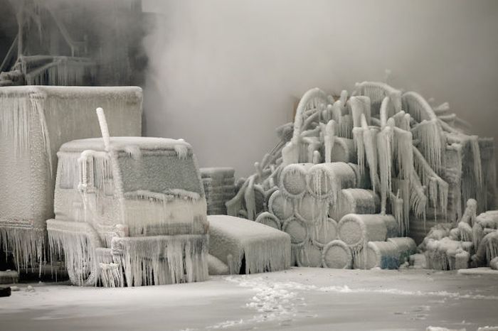 A truck is covered in ice as firefighters help to extinguish a massive blaze at a vacant warehouse in Chicago, Illinois. More than 200 firefighters battled a five-alarm fire as temperatures were in the single digits.