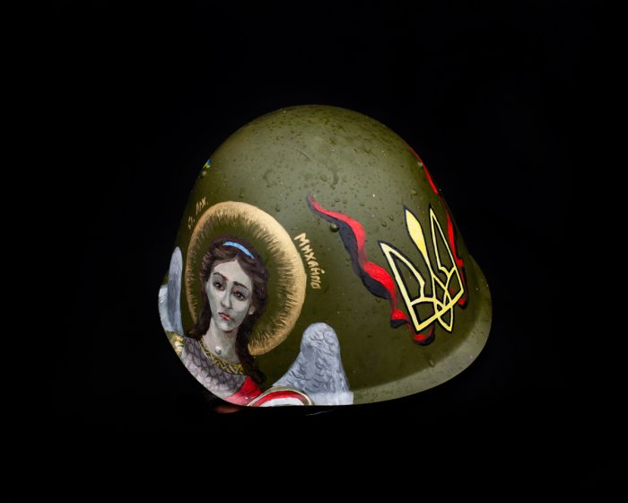 This protester's helmet is painted with an image of St. Michael, next to the Ukrainian crest