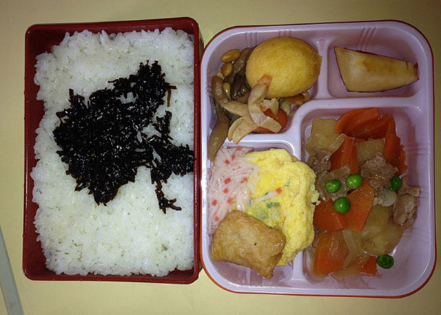 Country: Japan. Contents: Rice wkonbu a sweet seaweed, nikkujagga beef with veggies, omelette, sausage, potato puff, and apple.