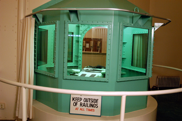 Chamber DescriptionThe California execution chamber is a self-contained unit at San Quentin State Prison which includes:    Witness areaEntered via a door to the outside, the witness area has a view of the chamber through five windows.    Execution chamberAn octagonal vacuum chamber, approximately 7-12 feet in diameter. It is entered through a large oval door at the rear of the chamber.    AnteroomContains three telephones. One is kept open for use by the Governor the other is for use by the State Supreme Court and Attorney Generals Office the third is connected to the Wardens office. The lethal injections are administered from the anteroom. The area also includes the valves and immersion lever used for executions by lethal gas.    Chemical roomIncludes storage cabinets and a work bench, plus the chemical mixing pots, pipes and valves used for executions by lethal gas.    Two holding cellsEach contains a toilet and room for a mattress.    Kitchenofficers areaIncludes a sink, cabinet, counter area and resting area for staff.