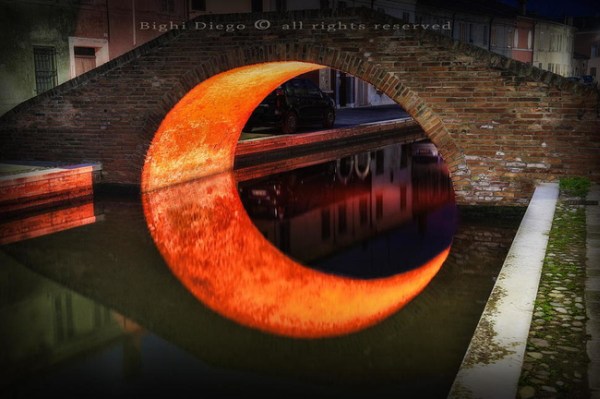 The Moon Bridge in Ferrara, Italy, captures the distinct beauty of a perfect crescent moon