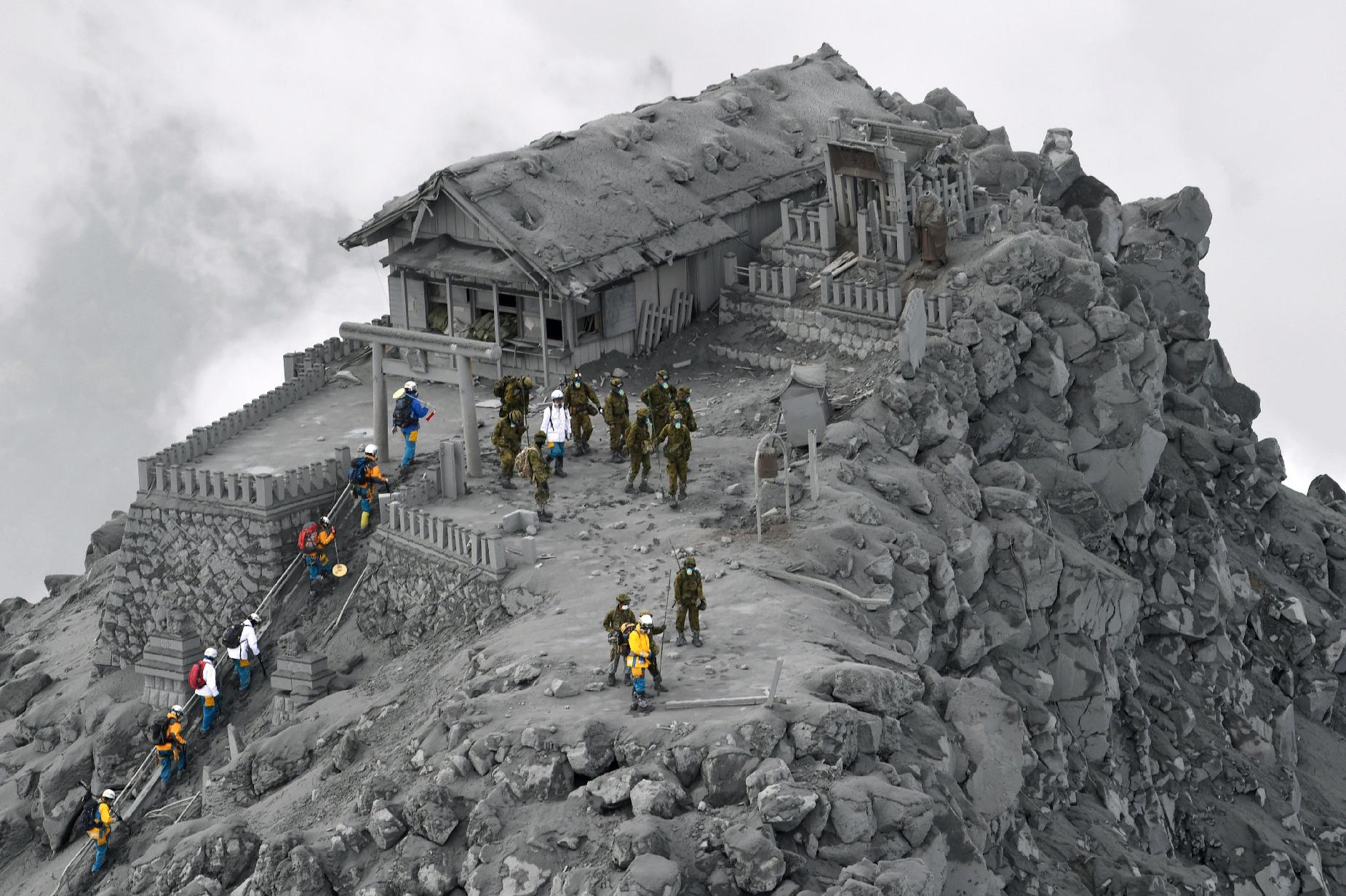 Rescuers at a shrine near the summit of Mt. Ontake, the volcano which erupted last week, killing at least 51 with 13 still buried under rocks and ash.