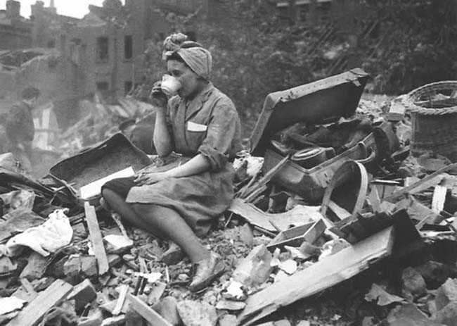 A woman drinking tea in the aftermath of a German bombing raid during the London Blitz. 1940