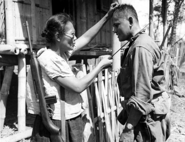 Filipino guerilla, Captain Nieves Fernandez, shows a US soldier how she killed Japanese soldiers during the occupation. 1944