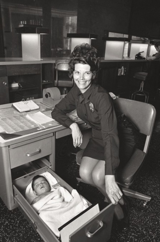 A Los Angeles Police Officer looks after an abandoned baby in the drawer of her desk. 1971