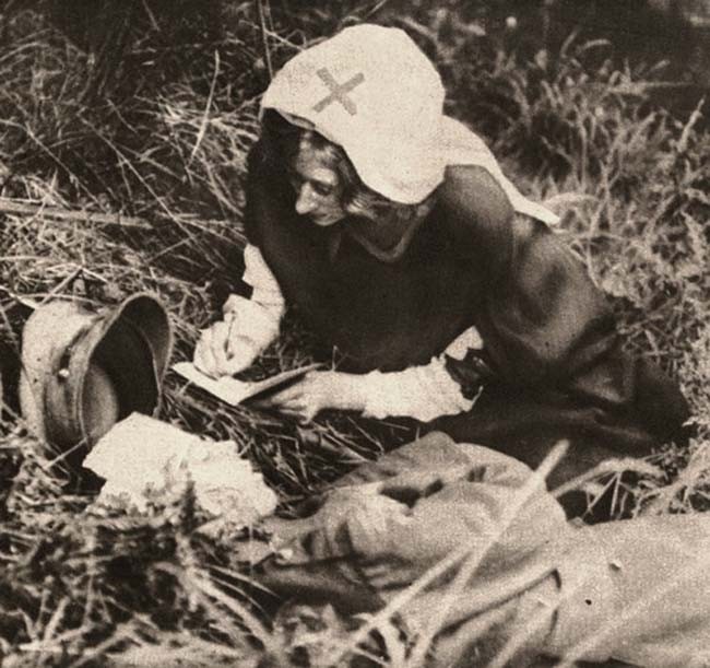 A Red Cross nurse takes down the last words of a British soldier. c. 1917