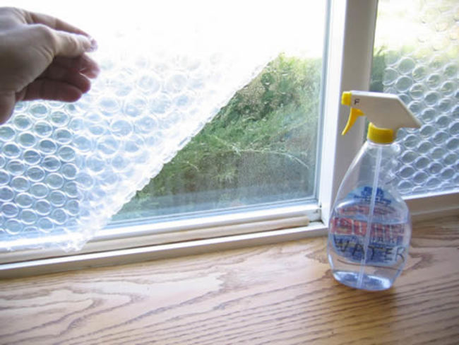 Take it one step further with DIY bubble wrap insulation. All you need is some leftover sheets of bubble wrap, an Exacto knife, and a spray bottle full of water, and you could reduce window heat loss by 50%.