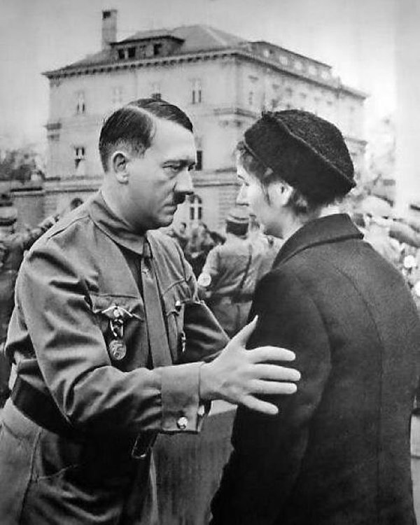Adolf Hitler comforting a widow at a funeral.