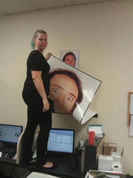 Super large picture of Nicolas Cage being taken off and there is a smaller version of the image right under it.