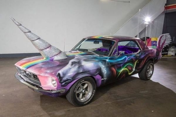 Car with hot neon paint job and a unicorn horn.