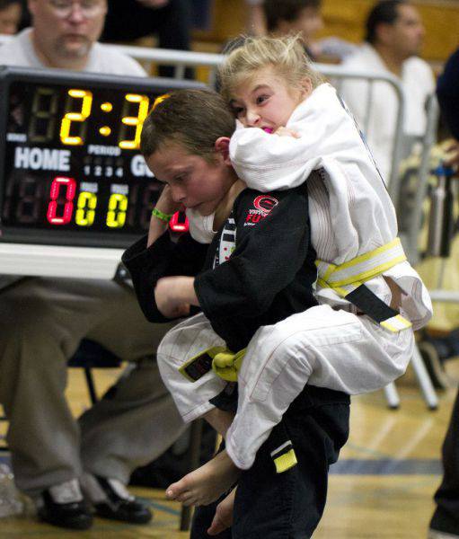 Little girl chocking out a boy opponent