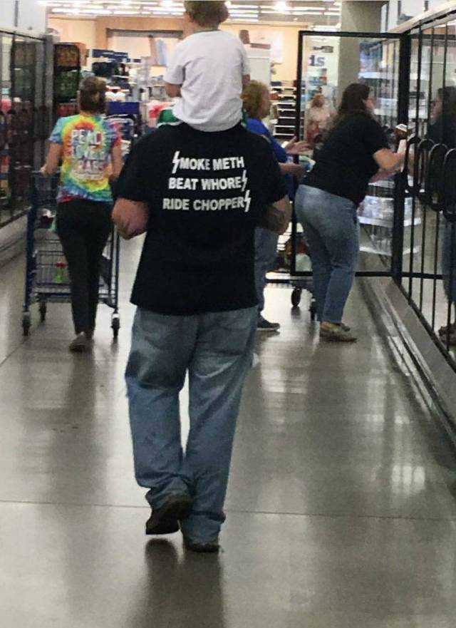 Man with crass shirt carrying his kid on his shoulders