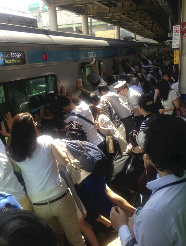 Commuters in Tokyo push a train car to save a stuck woman.