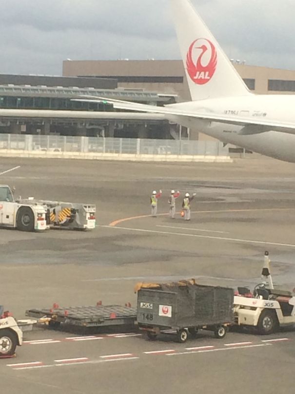 Ground crew waves goodbye to departing plane.