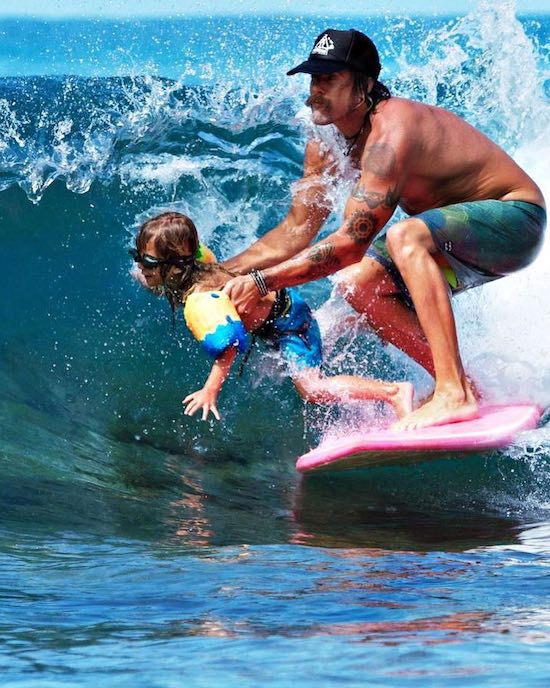 dad reflexes picture of man saving kid from falling in the water while surfing with him on same surfboard