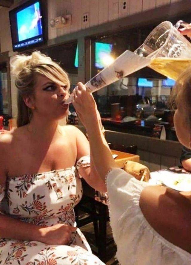 girl using paper roll to funnel down a beer