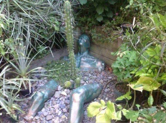 funny looking statue with cactus growing out of his groin