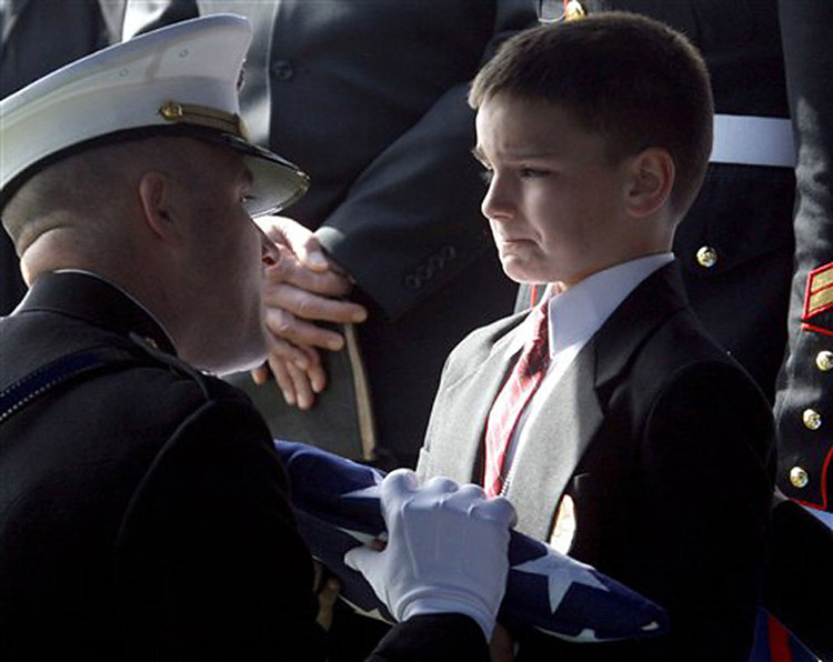 Eight-year-old Christian Golczynski accepts the flag for his father, Marine Staff Sgt. Marc Golczynski,