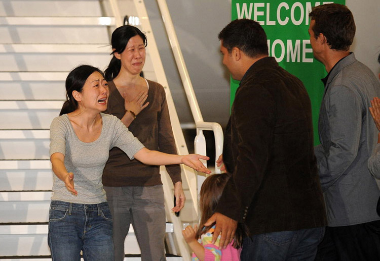 Journalists Euna Lee and Laura Ling, who had been arrested in North Korea and sentenced to 12 years hard labor, are reunited with their families in California after a successful diplomatic intervention by the U.S.