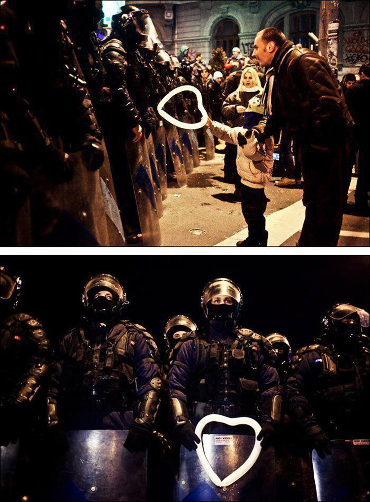Romanian child hands a heart-shaped balloon to riot police during protests against austerity measures in Bucharest.