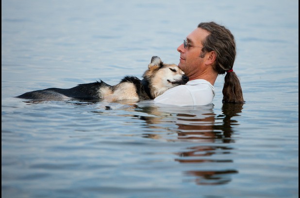 John Unger cradles his 19-year-old dog Schoep to sleep every night in Lake Superior so the buoyancy of the water can sooth his arthritic pain
