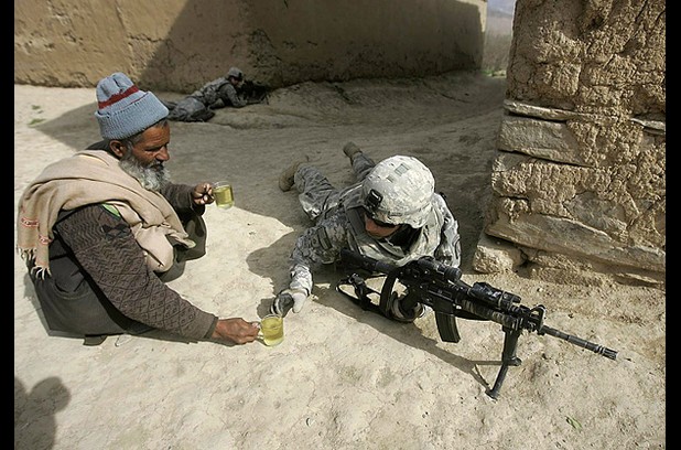 An Afghan man offers tea to thirsty fighting American soldiers