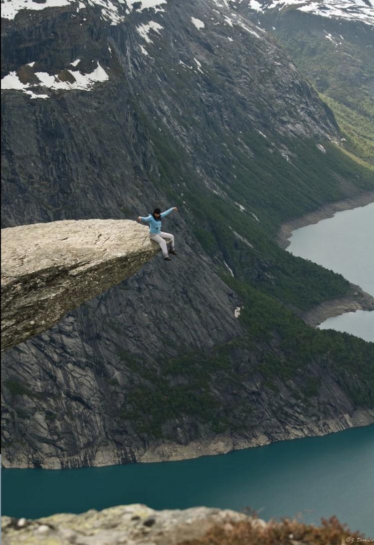 Sitting on the Trolltunga rock in Norway