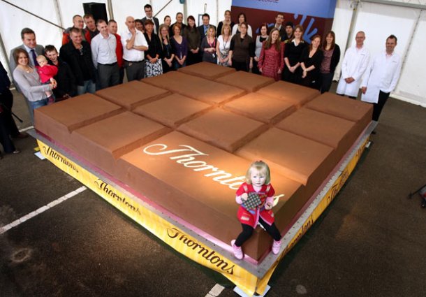 The largest chocolate bar weighed 12,770 pounds and was created by Thorntons plc in Alfreton, Derbyshire, UK on 7 October 2011. The chocolate bar measured 13 feet 1.48 inches by 13 feet 1.48 inches by 1 foot 1.78 inches